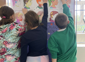 gazetka szkolna przedstawiająca ilustracje chłopców i dziewczynek z aparatami i implantami wspomagającymi słuch - wykonane przez uczniów