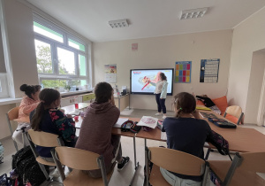uczniowie siedzą w ławkach i słuchają o budowie ucha