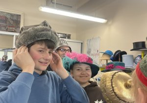 Dwoje uczniów pozuje do zdjęcia w kapeluszach.